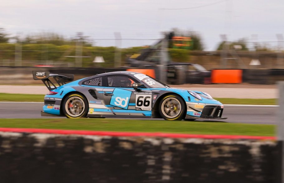 Porsche 911 GT3 racing car in blue and black, speeding on a track.